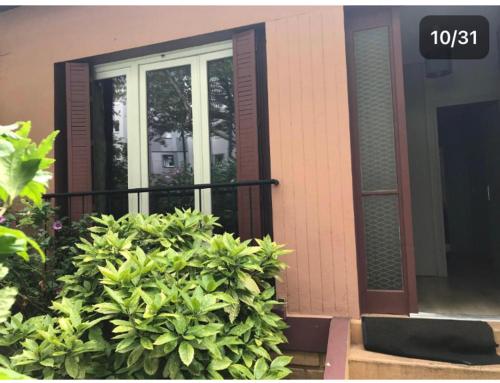 a house with a window and a bush in front of it at Pavillon 1 à 4 personnes chez l’habitant parfait pour une famille in Bagneux