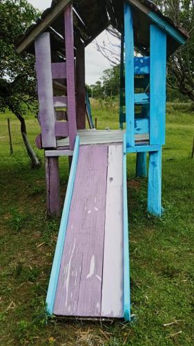 a wooden play structure sitting in the grass at Cabaña Los Nietitos in Tranqueras