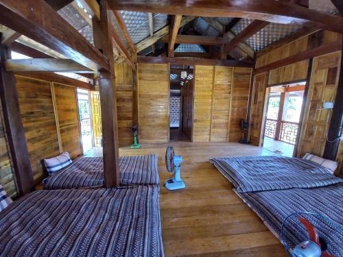 Retreat Home Bản Dọi Mộc Châu في موك تشاو: سريرين في غرفة بجدران خشبية وأرضيات خشبية