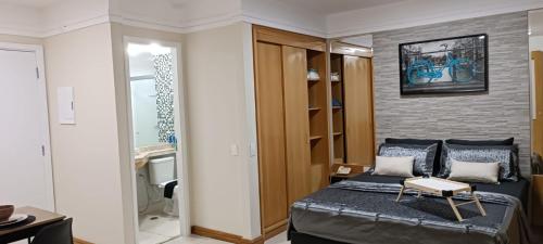 um quarto com uma cama e uma parede de tijolos em Executive Flat Bela Cintra 704 em São Paulo