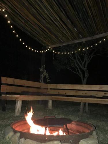 a fire pit in front of a bench at night at Cabaña Los Nietitos in Tranqueras