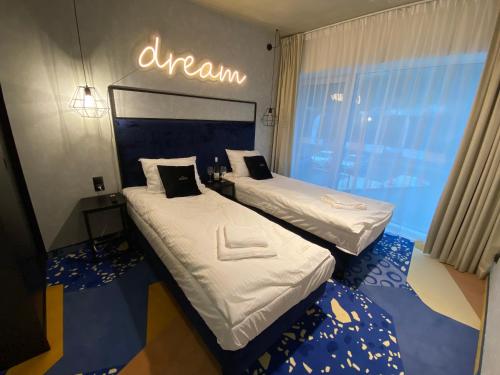 Dos camas en una habitación con un cartel que lee el sueño en Apartment BIKE PARK Czarna Góra Resort, en Sienna