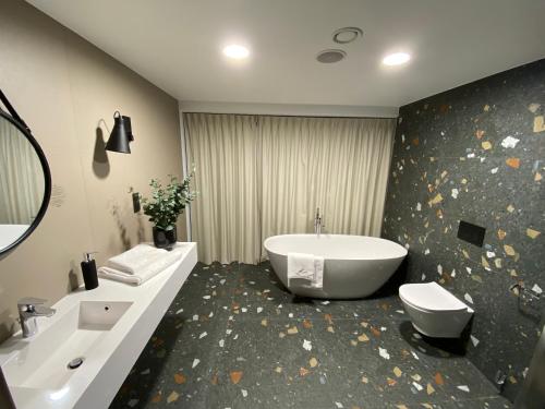 y baño con bañera, aseo y lavamanos. en Apartment BIKE PARK Czarna Góra Resort, en Sienna