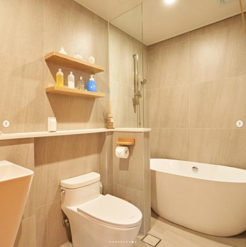 a bathroom with a toilet and a tub and a sink at Gyeongju Hanok Sohwa in Gyeongju