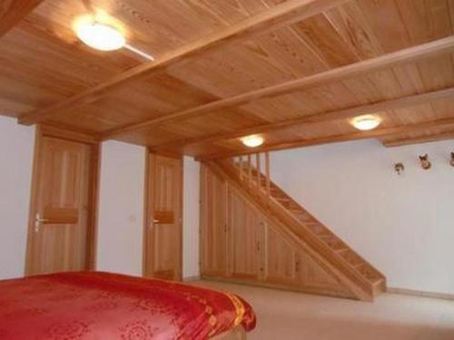 Habitación con escalera de madera y sofá rojo. en Casa Isabella - b48559, en Peccia