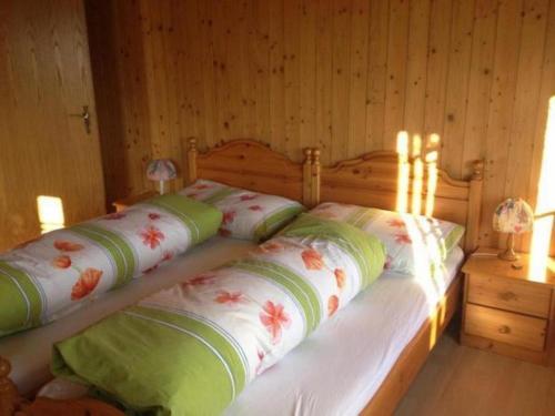 a bedroom with a wooden bed with pillows on it at Guntern in Lauerz - b48507 in Lauerz