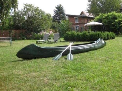 ein Boot, das auf dem Rasen im Hof sitzt in der Unterkunft Gemütliches Ferienhaus in Lindow Mark mit Garten und Grill - b48500 in Lindow