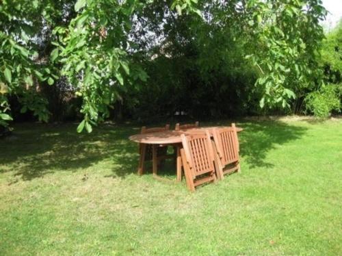 una mesa de picnic y un banco en un campo de hierba en Gemütliches Ferienhaus in Lindow Mark mit Garten und Grill - b48500, en Lindow