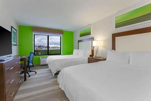 Habitación de hotel con 2 camas, escritorio y TV. en Holiday Inn Express & Suites Downtown, en Fort Worth