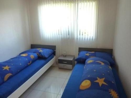 een slaapkamer met 2 bedden met blauwe lakens en sterren bij Oberwilen - b48548 in Vitznau