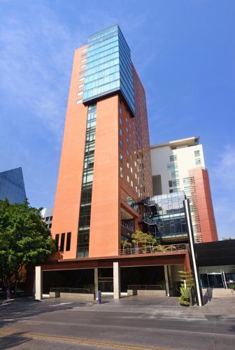 a tall building with glass windows on top of it at Hotel Guadalajara Country Club by HNF in Guadalajara