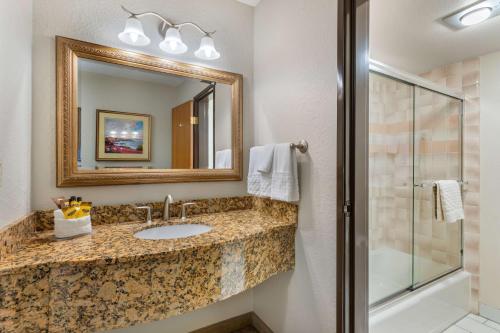 a bathroom with a sink and a mirror and a shower at Best Western Plus Monterey Inn in Monterey