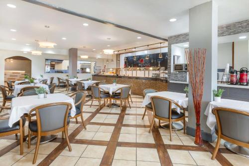 a restaurant with white tables and chairs and a counter at Best Western Plus El Paso Airport Hotel & Conference Center in El Paso