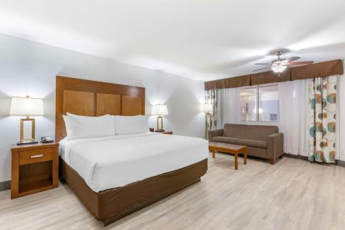 Best Western Plus El Paso Airport Hotel & Conference Center في الباسو: غرفة في الفندق بسرير وكرسي وأريكة