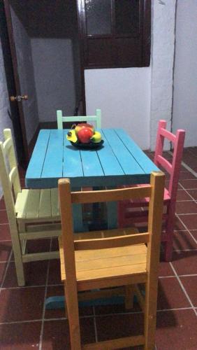 - une table bleue avec des chaises et un bol de fruits dans l'établissement CASA HOSTAL GUADALUPE, à Guadalupe