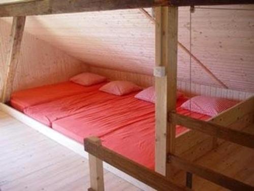 a bunk bed with red sheets and pillows on it at Alphütte Chilchschwand - b48558 in Stalden