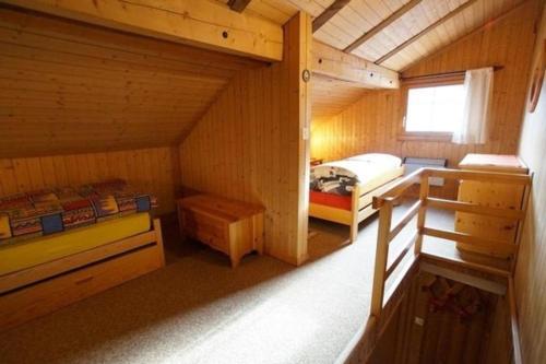 a small room with a bed in a cabin at Ferienwohnung Fontauna Rustikale Maisonette-Wohnung im Zentrum von Sedrun - b48529 in Sedrun