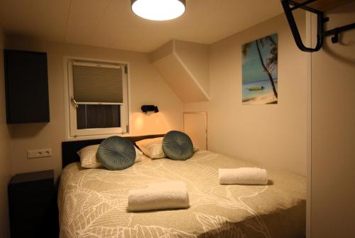 a bedroom with a bed with two pillows on it at Houseboat Trinidad in Maastricht