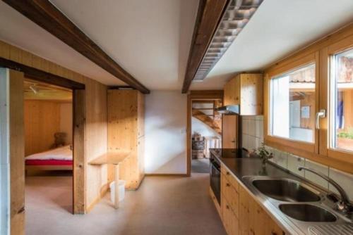 a kitchen with a sink and a room with a bed at Haus Eberli-Bussmann - b48553 in Giswil