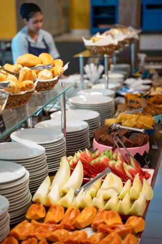 a buffet of food with plates and fruit on display at Pousada dos Gravatás in Búzios