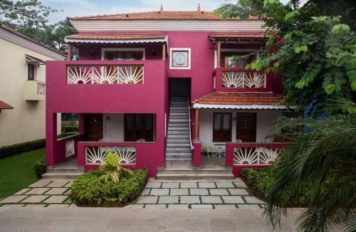 a pink house with a staircase in front of it at Radisson Blu Resort, Goa in Cavelossim