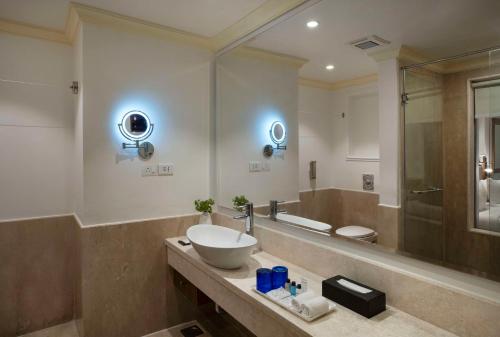 a bathroom with a sink and a large mirror at Radisson Blu Resort, Goa in Cavelossim