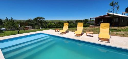 a group of yellow lounge chairs and a swimming pool at Cabañas Potrero de Marquez in Potrero de Garay