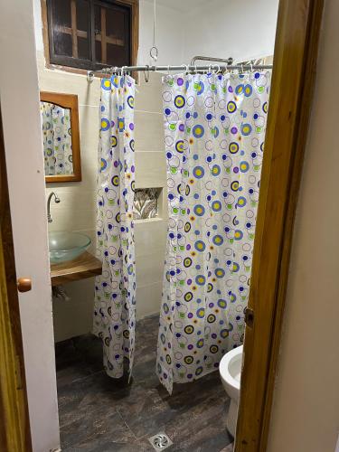 a bathroom with a shower curtain and a toilet at Cabaña #5 en Condominio Mar de Coveñas in Coveñas