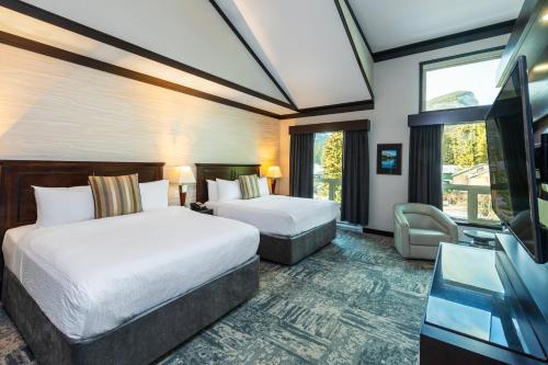 um quarto de hotel com duas camas e uma televisão de ecrã plano em Charltons Banff em Banff