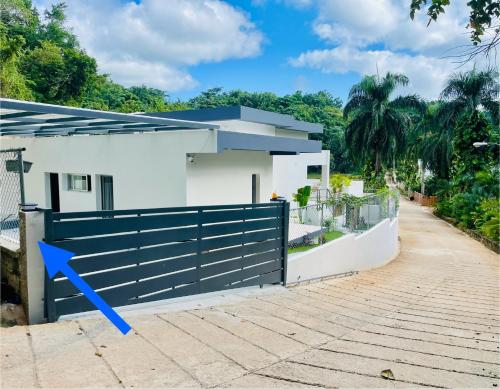 a white house with a blue fence at Cozy Studio in Private Villa in Las Terrenas