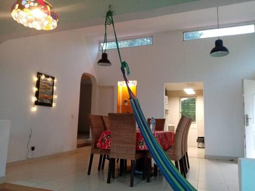 a dining room with a hammock hanging from the ceiling at Cabaña Holly Water in Cerro Azul
