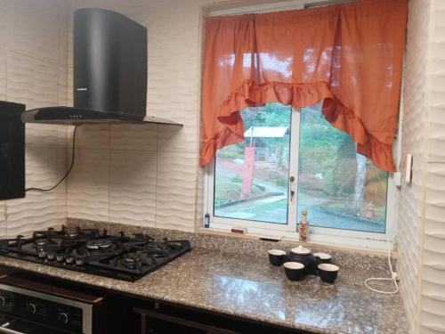 a kitchen counter with a stove and a window at Cabaña Holly Water in Cerro Azul