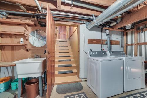 een wasruimte met een wastafel en een wasmachine bij Roscommon Cabin, Walk to Higgins Lake in Roscommon