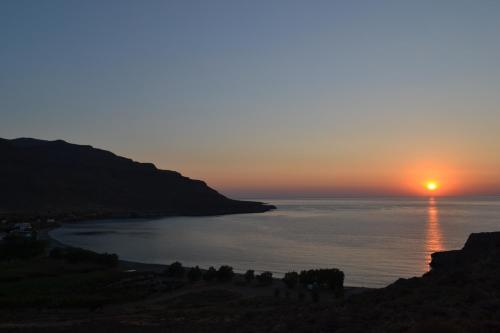 a sunset over a body of water at Katerina Apartments in Káto Zákros