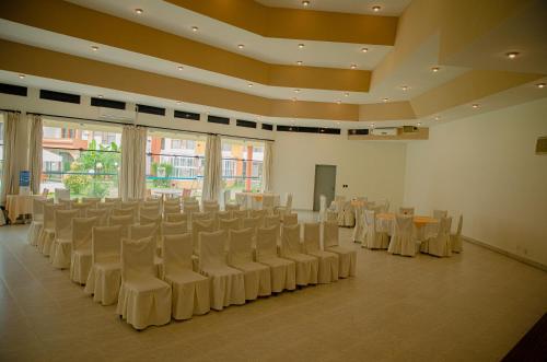 a banquet hall with white chairs and tables and windows at Hotel Viña del Sur in Tarija