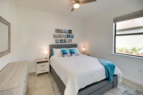 sypialnia z łóżkiem z niebieskimi poduszkami i oknem w obiekcie Alva Vacation Rental with Pool and Golf Course Access! w mieście Lehigh Acres