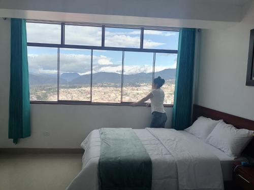 a woman looking out the window of a hotel room at HOSTAL EL MIRADOR CHACHAPOYAS in Chachapoyas