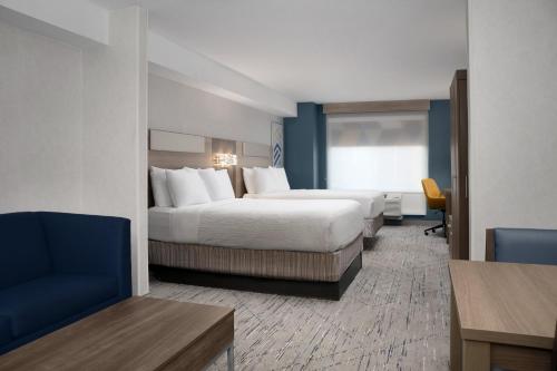 una habitación de hotel con 2 camas y una silla en Holiday Inn Express & Suites Alexandria - Fort Belvoir, an IHG Hotel, en Alexandria