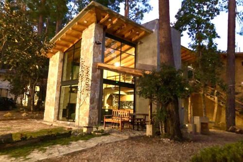 a house with large glass windows and a tree at Bolonchon cabin. Comfortable, modern and cozy in San Cristóbal de Las Casas