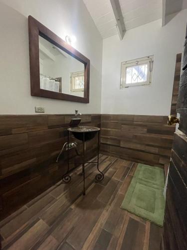 uma casa de banho com um espelho e um banco num quarto em CASA AUM VALLE DE GPE em Villa de Juárez