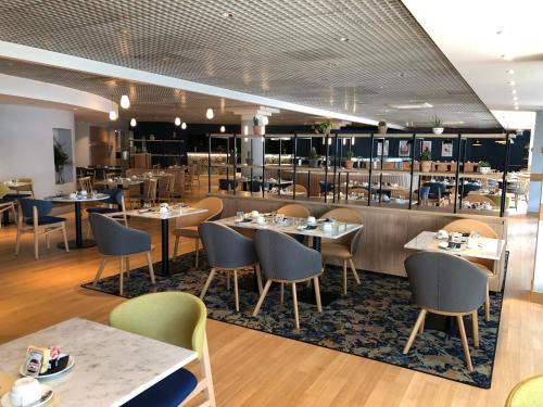 a dining room with tables and chairs in a restaurant at Crowne Plaza Milan Linate by IHG in San Donato Milanese