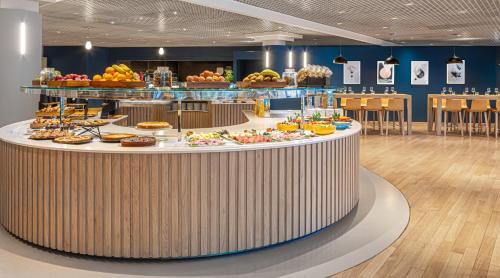 a cafeteria with a large counter with food on it at Crowne Plaza Milan Linate by IHG in San Donato Milanese