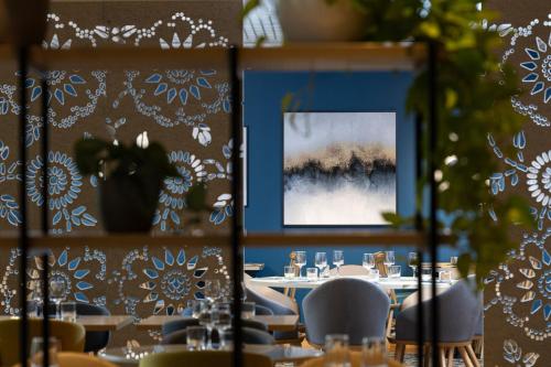 a dining room with tables and chairs and a picture at Crowne Plaza Milan Linate by IHG in San Donato Milanese