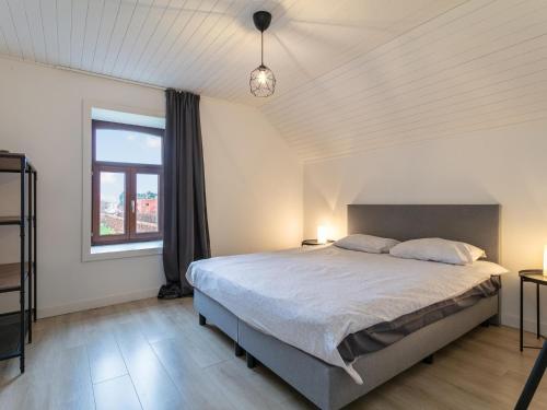 a bedroom with a large bed and a window at De Marckhoeve in Merksplas
