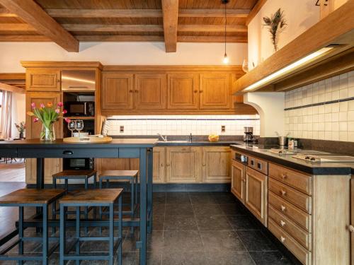 a kitchen with wooden cabinets and a blue island at De Marckhoeve in Merksplas
