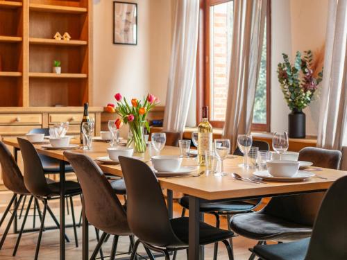 a dining room with a table with chairs and wine bottles at De Marckhoeve in Merksplas