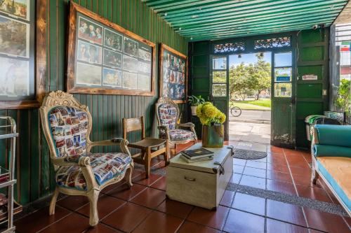 ボゴタにあるHotel Casa Antiguaの椅子2脚、テーブル、テーブルサイドが備わる客室です。