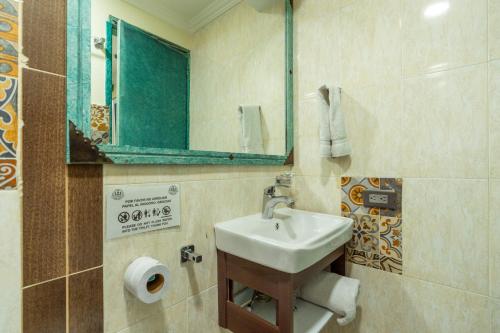 a bathroom with a sink and a mirror at Hotel Casa Antigua in Bogotá