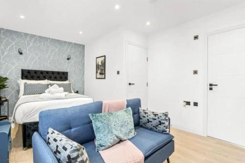 a bedroom with a blue couch and a bed at Luxury Entire Apartment in Cowley