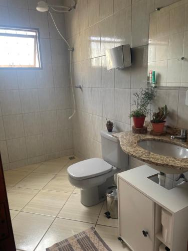 a bathroom with a toilet and a sink at Homeoffice Central 1 quarto 1 cama de casal banheiro privativo in Alfenas